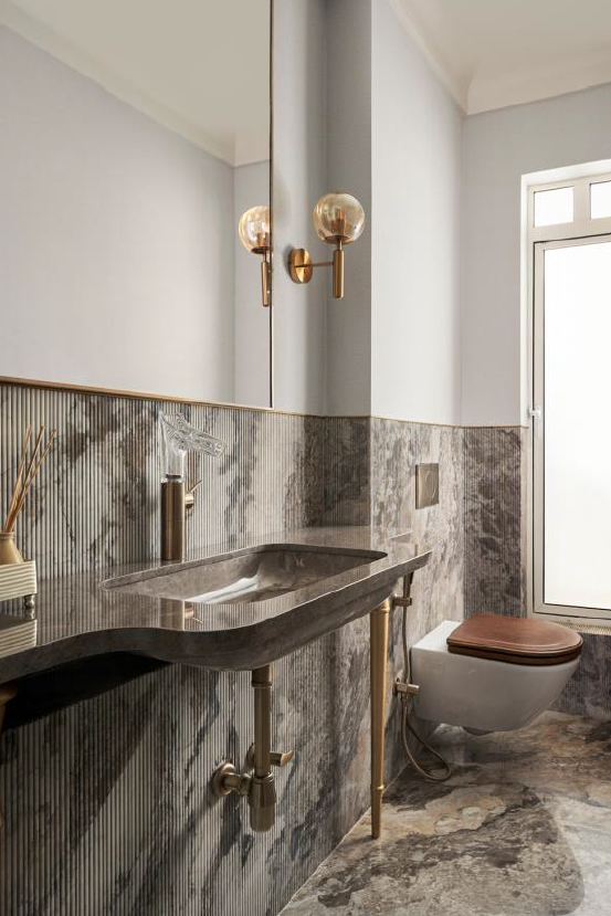 Stylish bathroom featuring a marble sink, modern fixtures, and elegant lighting, showcasing contemporary design elements.