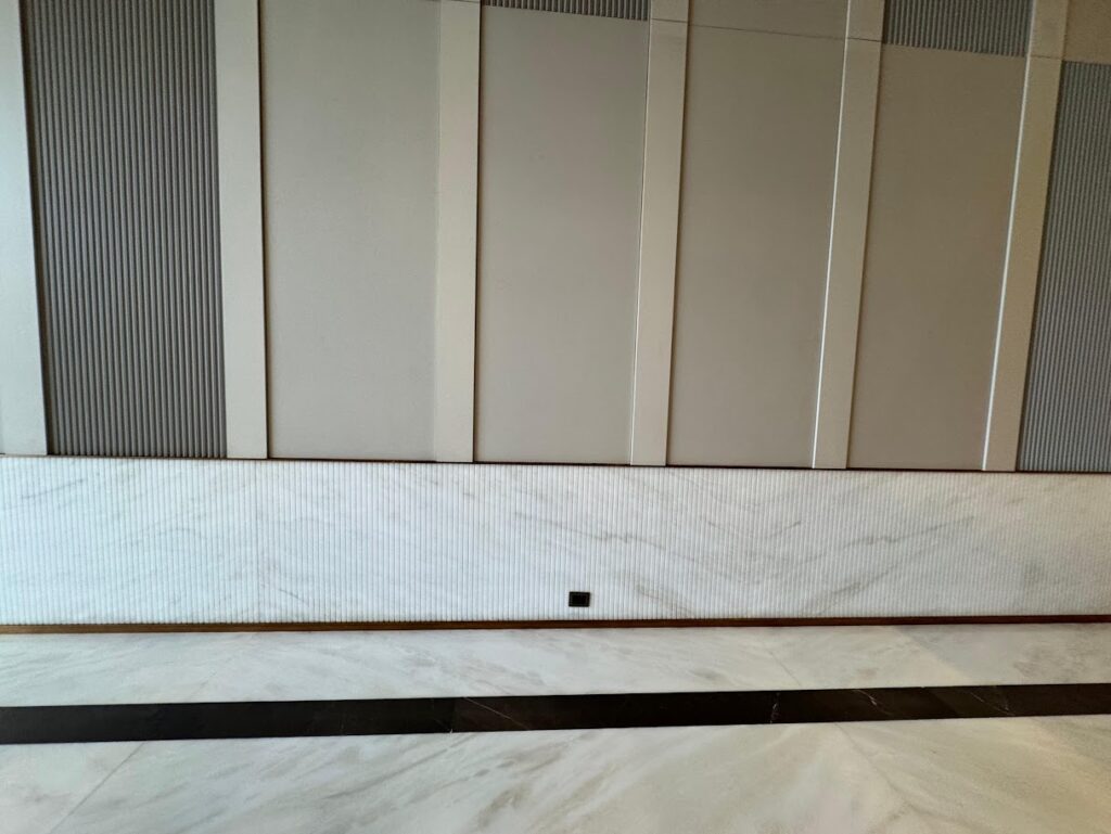 Modern interior wall design featuring textured panels and a marble base, highlighting elegant architectural elements.