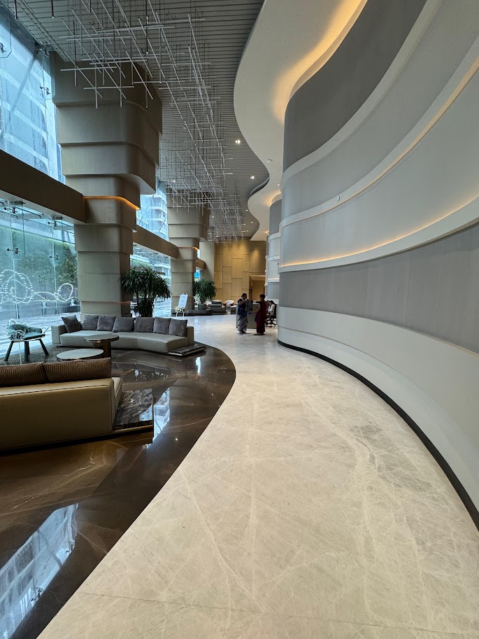 Modern lobby featuring curved walls, elegant seating, and natural light, showcasing a sophisticated design project.