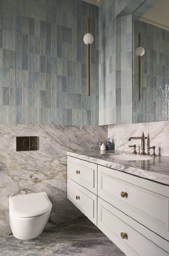 Stylish bathroom featuring blue tiled walls, marble countertops, and modern fixtures for a contemporary design.
