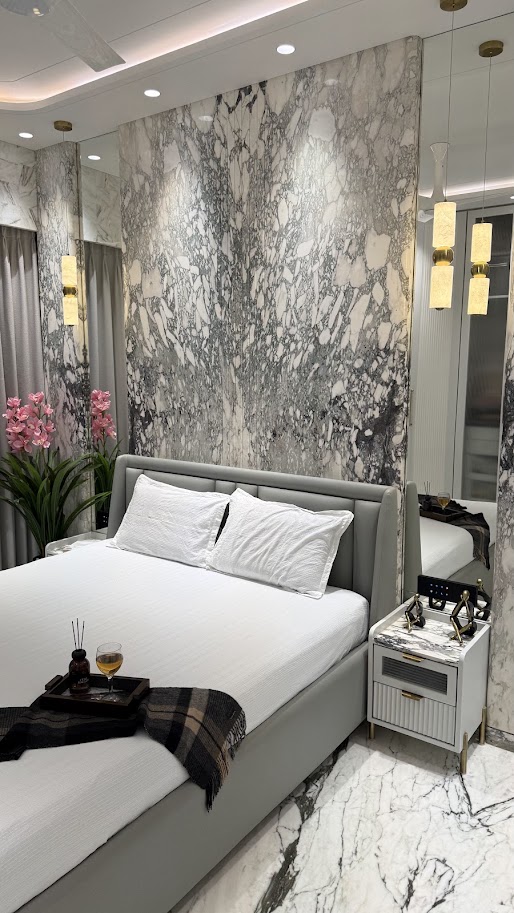 Stylish bedroom featuring a marble accent wall, modern furnishings, and elegant decor elements for a luxurious ambiance.