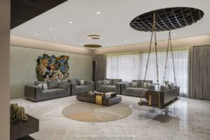 Modern living room featuring a unique swing seat, plush sofas, and vibrant wall art, designed for comfort and style.