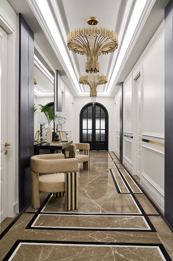 Elegant hallway featuring a luxurious chandelier, stylish seating, and sophisticated marble flooring design.