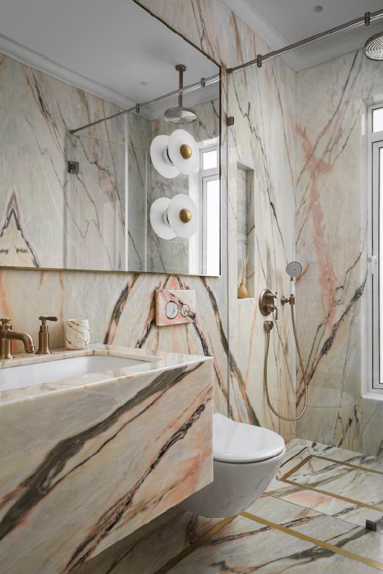 Luxurious bathroom featuring elegant marble walls, modern fixtures, and a spacious shower area.