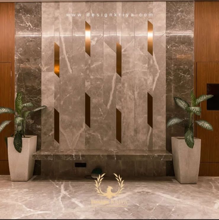 Elegant marble wall with vertical cutouts and potted plants, showcasing modern interior design elements.